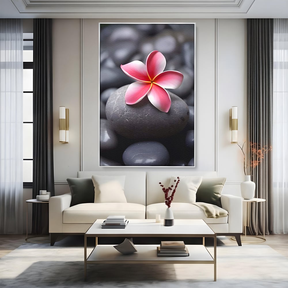 Tablou canvas cu floare roz pe pietre gri, in rama de aluminiu argintiu, pe perete intr-un living